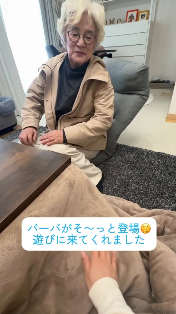 こたつの前で微笑む人