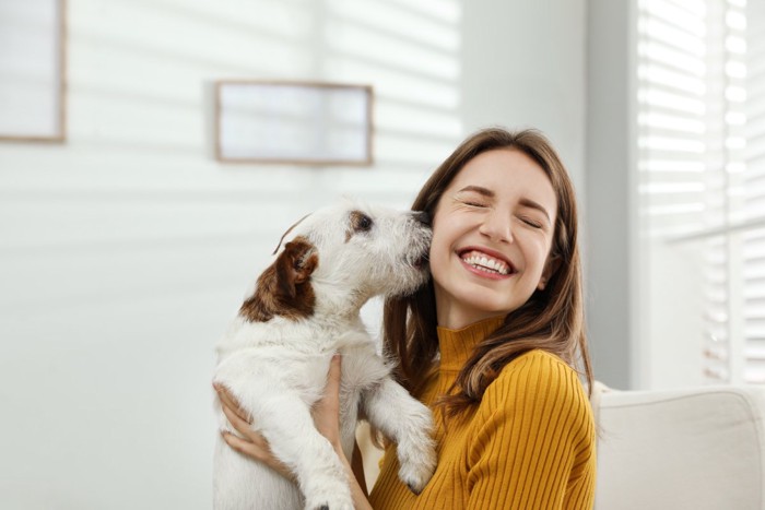 女性の顔を舐める犬
