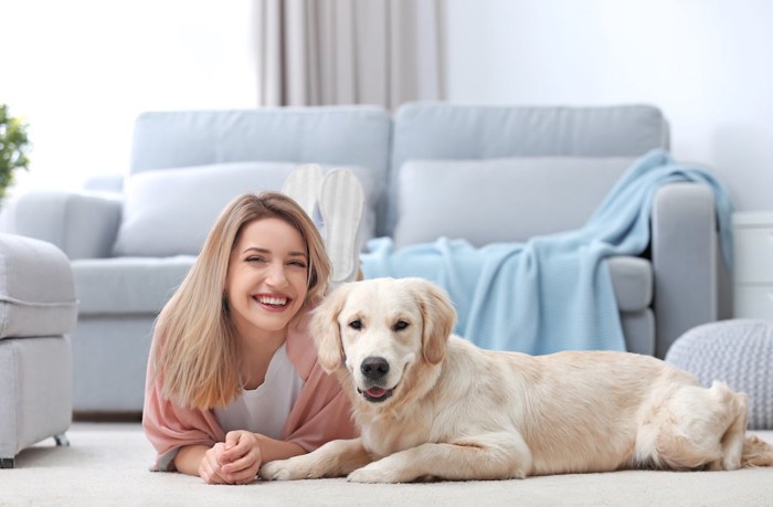 部屋でくつろぐ笑顔の女性と犬