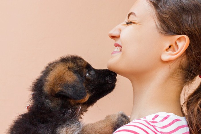 女性のアゴに鼻をつける子犬