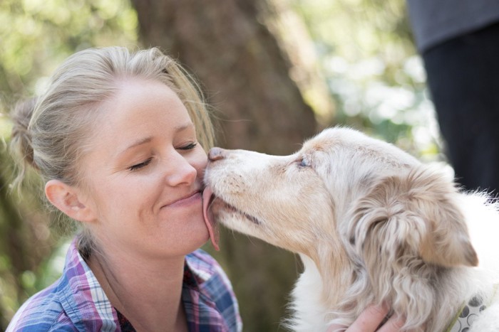 女性の口を舐める犬