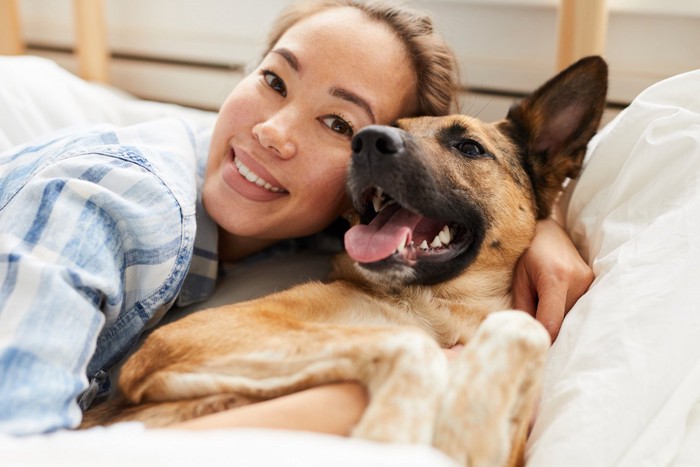 頬を寄せ合う犬と女性