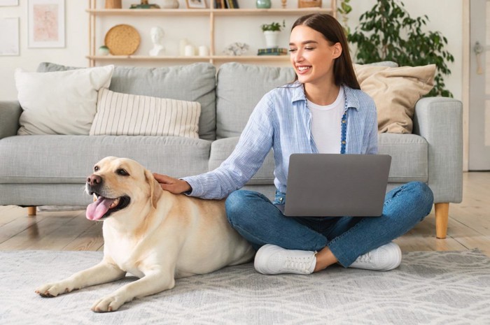 在宅ワーク中の女性と大型犬