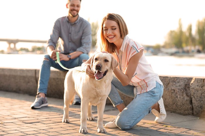 犬を連れた男性と犬を撫でる女性