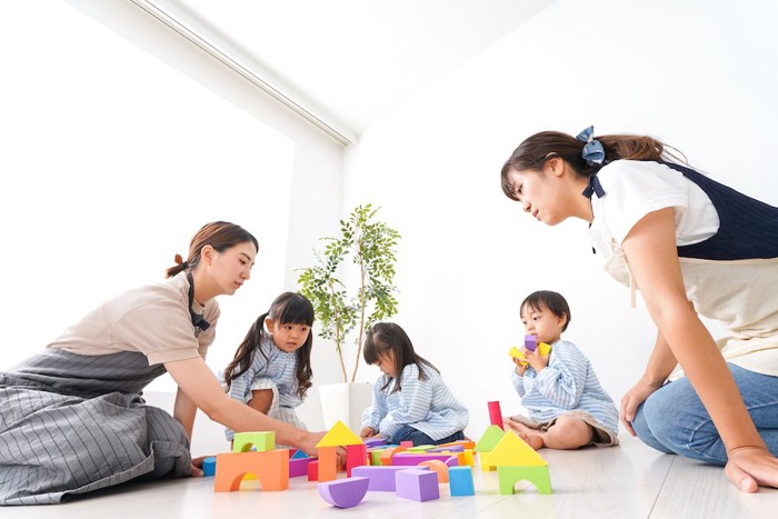 積み木で遊んでいる子どもたちと母親たち