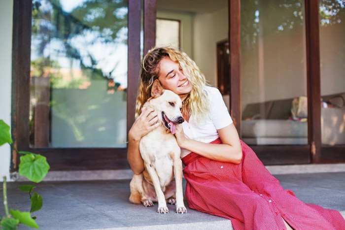 テラスで女性と寄り添い合う犬