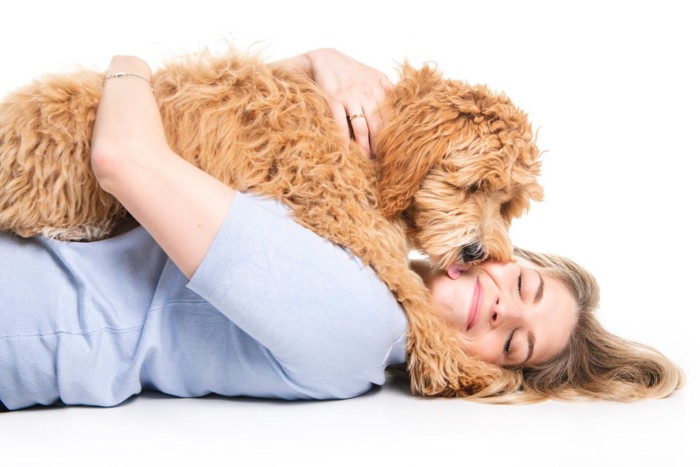 女性の上に乗ってキスする犬