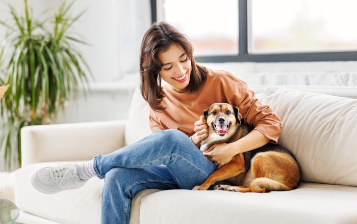 愛犬と寄り添って座る女性