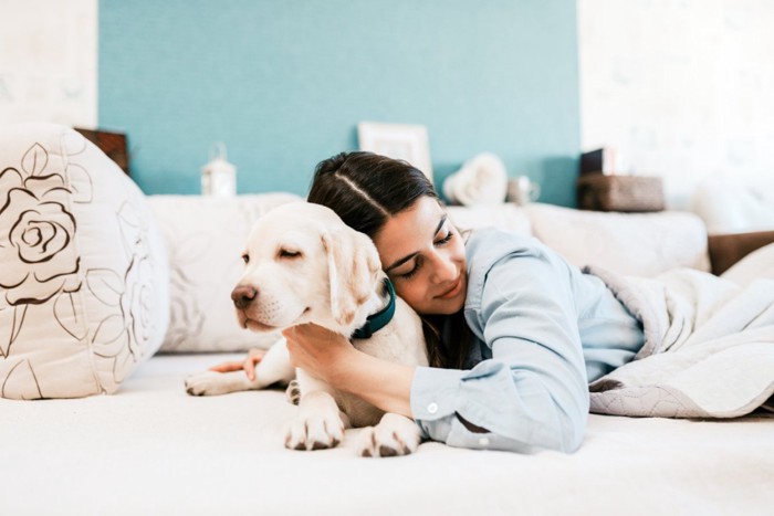 寝てる犬を抱きしめる女性