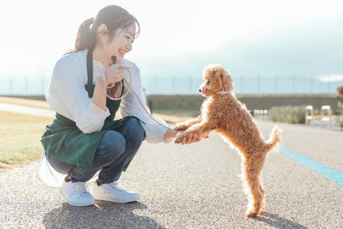 しゃがむ女性と犬