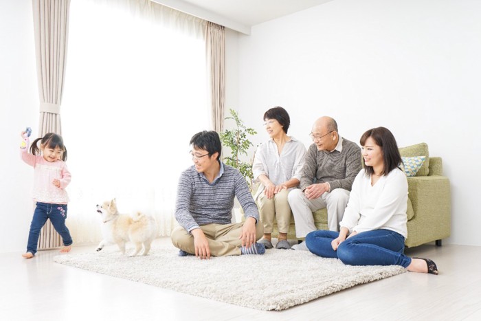 部屋で遊ぶ家族と犬