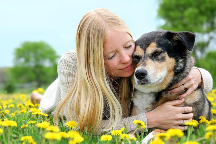 飼い主に抱きしめられる犬