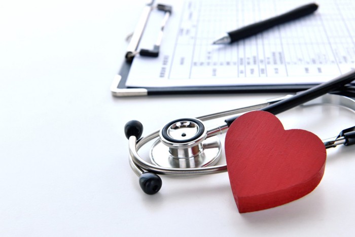 カルテと聴診器と赤いハートの模型