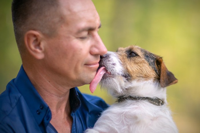 男性の顔を舐める犬