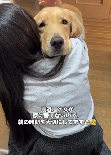 女の子の肩に顔を乗せる犬