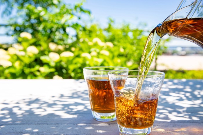 ピッチャーからグラスに麦茶を注いでいる様子