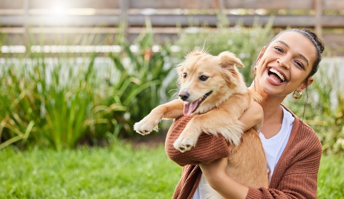 犬を抱き上げる女性