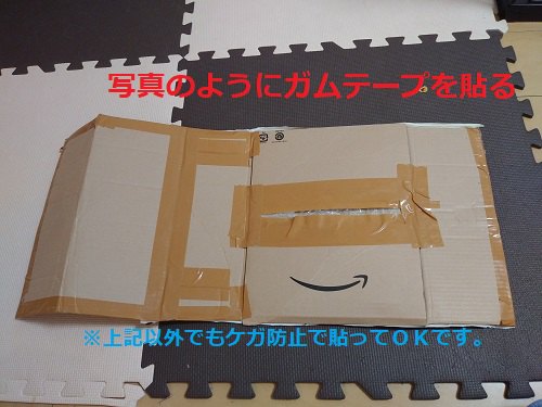 開いた段ボール ガムテープで貼っている 赤文字と水色文字