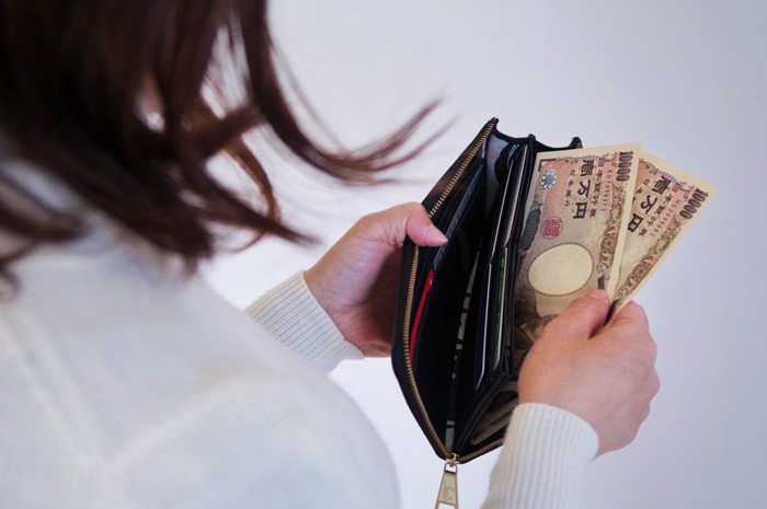 財布からお金を出す女性