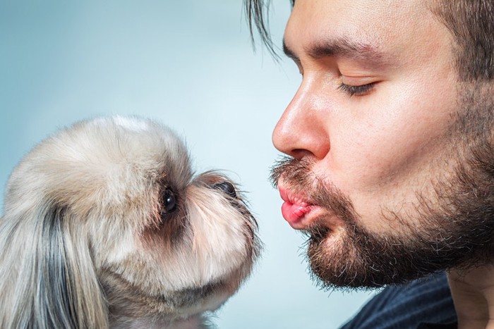 犬にキスをしようとする男性