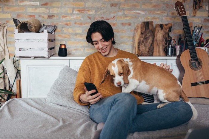 男性の膝の上に乗る犬