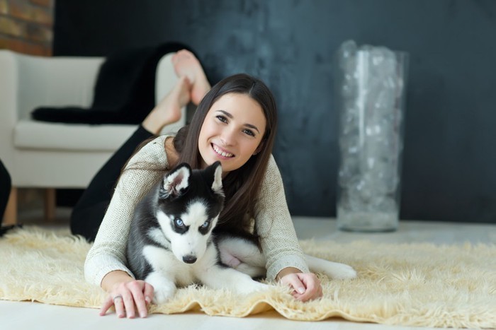 犬の後ろから覆い被さる女性