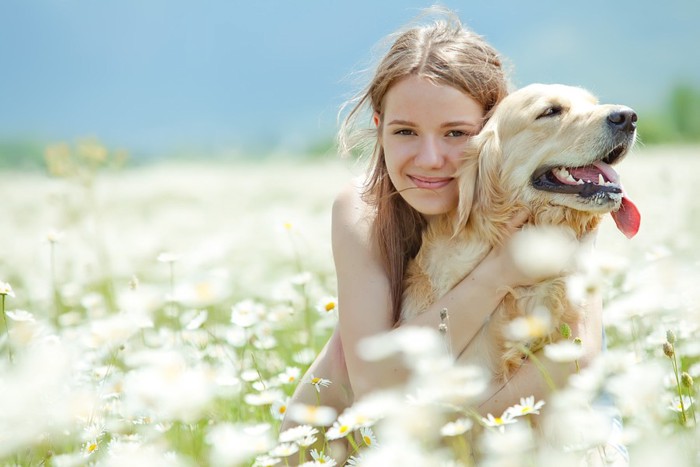 花畑で犬を抱く女性