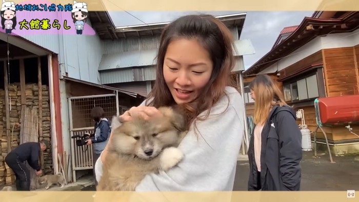 女性に抱っこされる仔犬