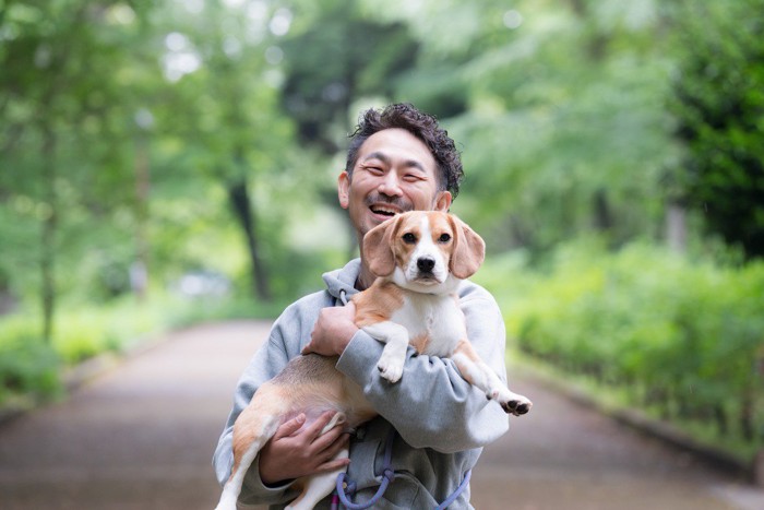 犬を抱っこする男性