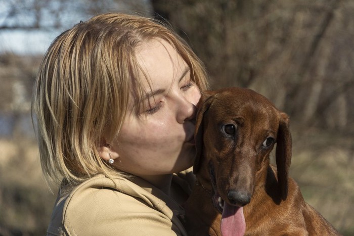 犬にキスをする金髪の女性