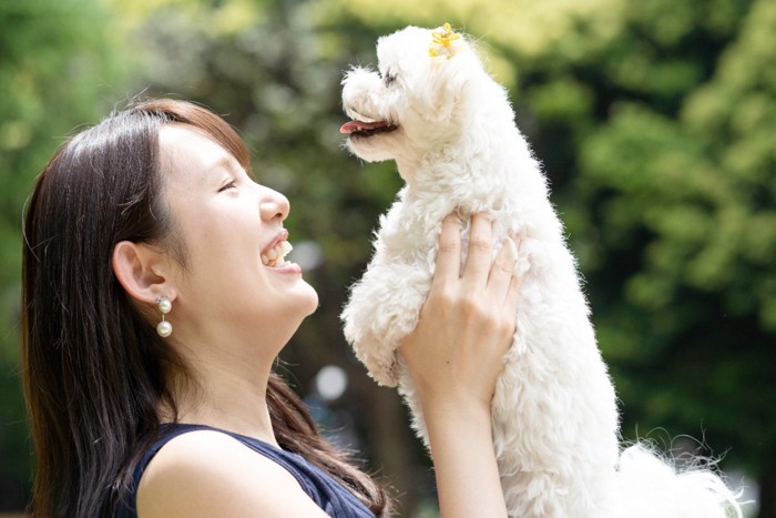 犬を抱き上げて笑顔の女性