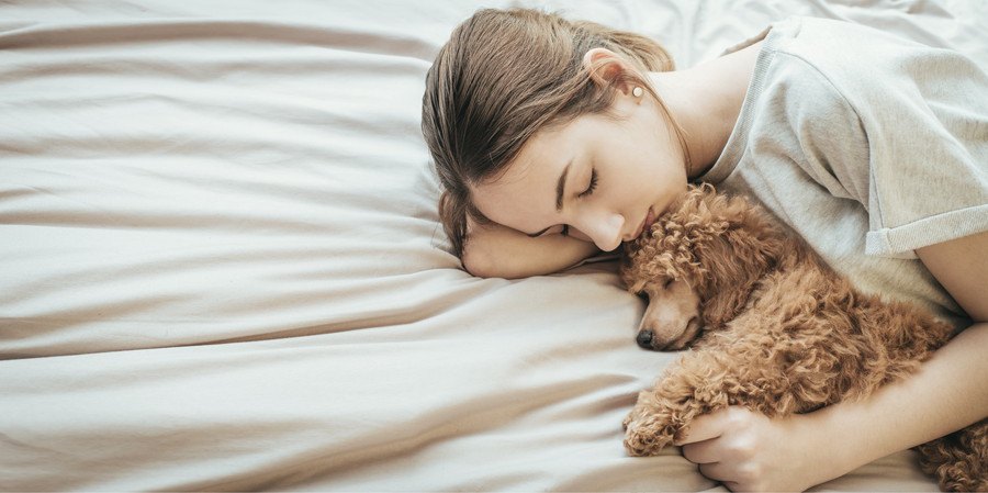 愛犬を抱きしめて眠る女性