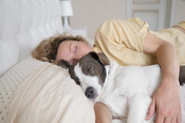 犬といっしょに眠る女性