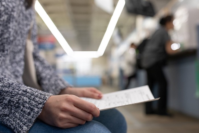 窓口に書類を提出しに行く女性