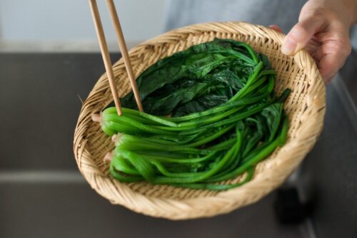 ざるにあげている茹で上がったほうれん草