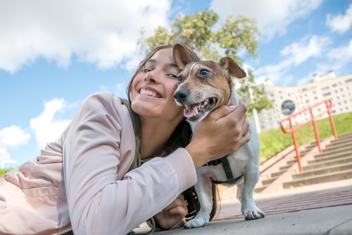 顔を寄せあう犬と女性