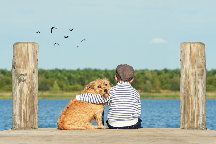 肩をくむ犬と子ども