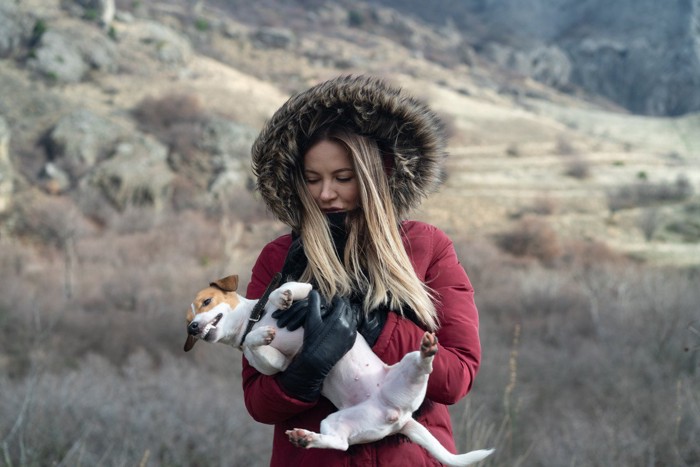 女性に抱かれて嫌がる犬