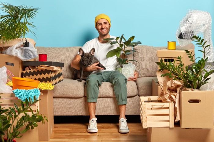 荷造り中のお部屋にいる飼い主さんと犬