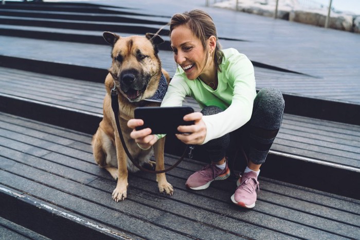 愛犬と一緒に写真を撮る女性