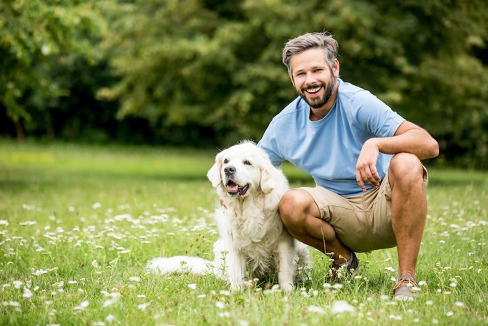 笑顔で犬を撫でる男性