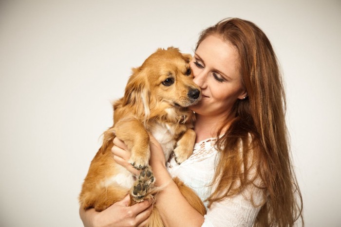 犬を抱っこしてキスする女性