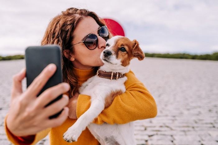 愛犬と写真を撮る女性