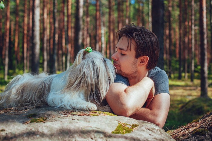 男性の顔のニオイを嗅ぐ犬