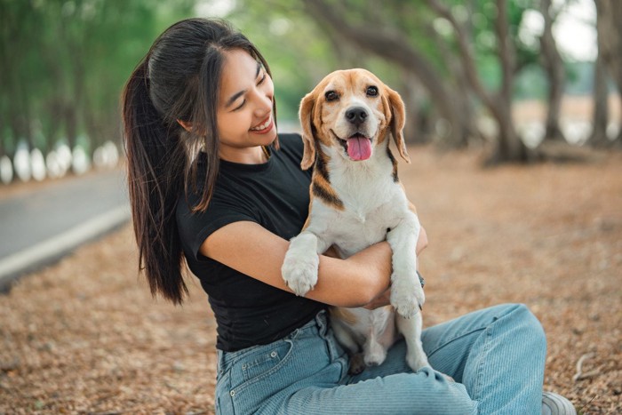 女性の膝の上でくつろぐ犬
