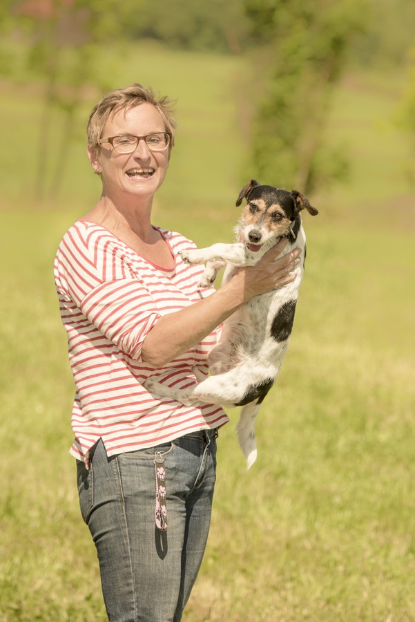 犬を抱っこするストライプの女性