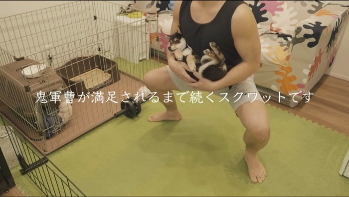 犬を抱いてスクワットをする飼い主