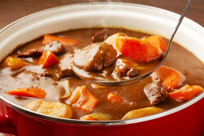 カレーが入った鍋からお玉で具材をすくい上げている様子