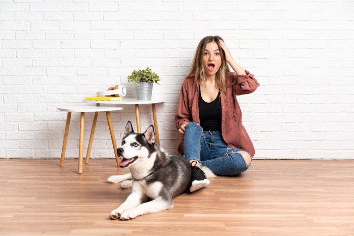 犬の隣で慌てた表情をする女性