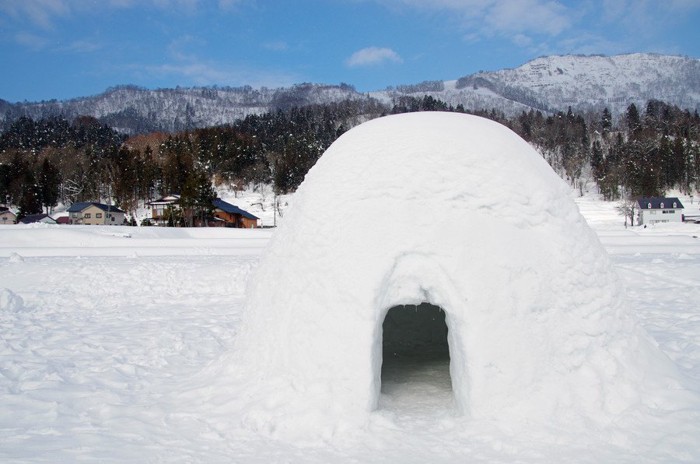 かまくら、青い空と雪山の背景